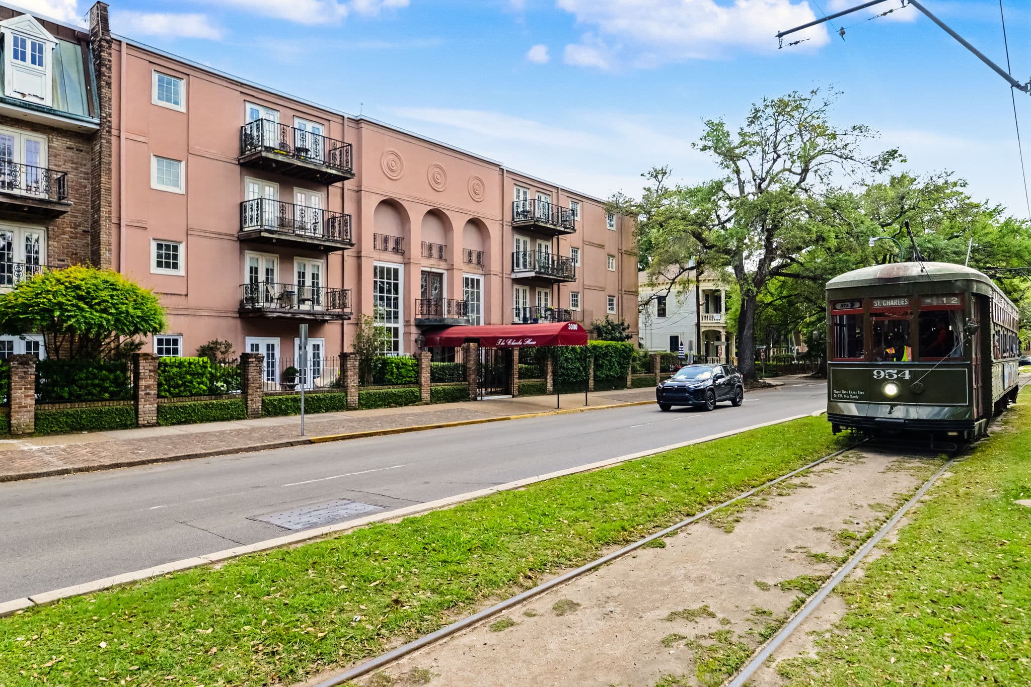 A St. Charles Avenue streetcar beside New Orleans homes